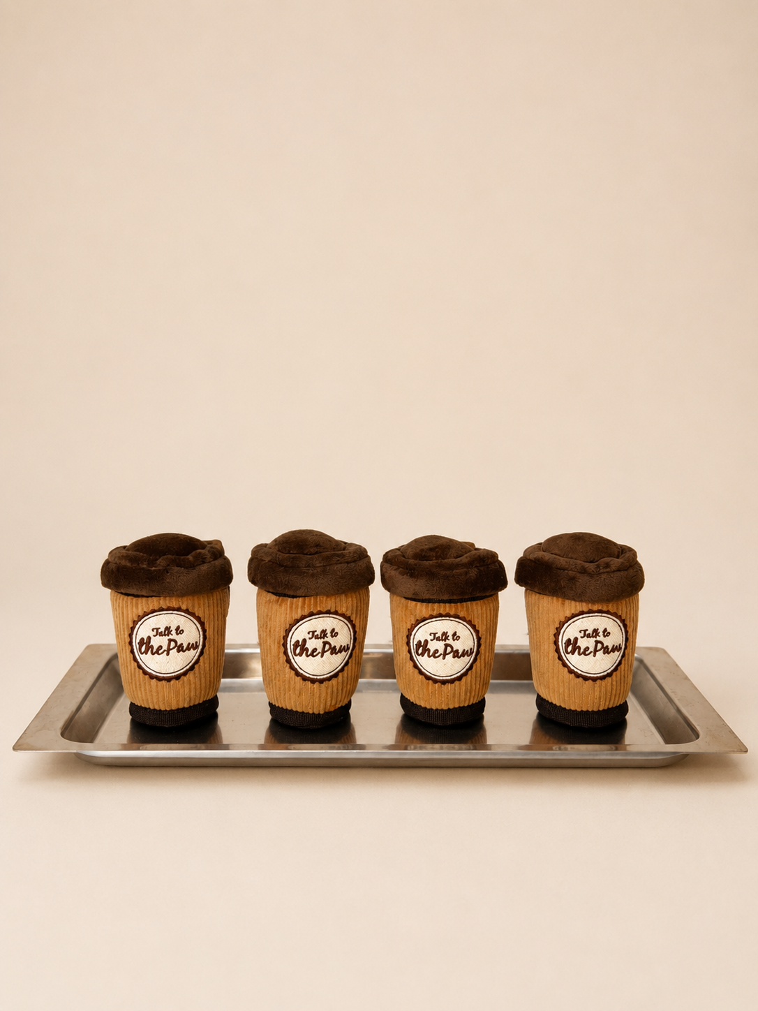 Puppuccino coffee cup plush dog toys on a neutral background